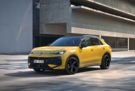 VW T-Roc | Das Bild zeigt einen gelben PKW vor einem Haus.