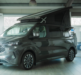 Auto Bäcker | Das Bild zeigt einen Camper mit aufgestelltem Dach im Schauraum.