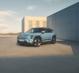 Kia EV2 | Das Bild zeigt einen hellblauen PKW vor einem modernen Gebäude.