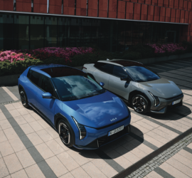Kia EV4 | Das Bild zeigt zwei PKW´s vor einem modernen Gebäude.