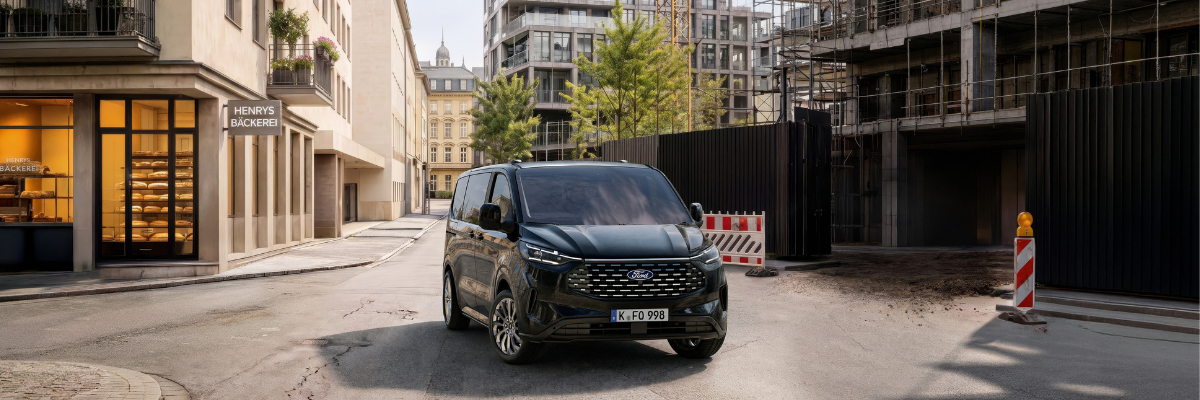 Angebot Ford Tourneo Custom | Jochem Gruppe | Das Bild zeigt ein Nutzfahrzeuge in der Stadt vor einer Baustelle.